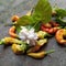 Curly chilies with beautiful colors and tiny jasmine flowers on the ground