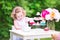 Curly cute toddler girl playing tea party with a doll