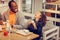 Curly dark-haired daughter laughing while having lunch with father