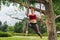 Curly dark-haired woman enjoying harmony doing aerial yoga