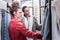 Curly dark-haired woman with hair bun helping her best friend choosing dress