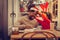 Curly daughter putting Christmas hat on her father sitting in cafeteria