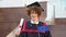 A curly funny smiling graduate in the master's mantle holds a diploma of completion of his studies and the flag of