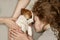 Curly girl and the children`s hands hugging a puppy