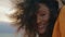 Curly girl smiling camera at gloomy nature close up. Portrait African woman.