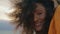 Curly girl smiling camera at gloomy nature close up. Portrait african woman.