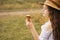 Curly girl in a straw hat eats ice cream in the village in the summer.