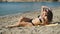 Curly girl in sunglasses sunbathing on the beach