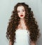 Curly hair woman portrait long hair with perfect make up red lips.