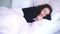 Curly-haired brunette girl sleeping and smiling. Portrait of happy calm caucasian woman resting in bedroom or hotel room