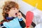 Curly-haired child indulges and grimaces in a dental chair