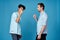 curly-haired guy in a shirt greets his friend on a blue background