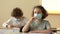 Curly-haired schoolgirl teenager in a protective mask during a lesson. Girl takes off her mask