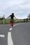 Curly-haired teenager balancing on road shoulder markings