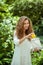 Curly-haired woman in white shirt putting a lemon into a bag