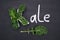 Curly-leaf kale cabbage inside letter K shaped plate, chalk inscription KALE on blackboard. Healthy food concept.  Flat lay or top