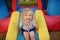 Curly little girl having fun in leisure center for kids. Child sport activity on outdoor playground. Toddler girl playing in