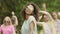 Curly mixed race woman dancing in slow motion, group of friends on background