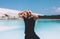 Curly model with curly hair is posing. Dressed all black. Tropical view, awesome nature. Crystal clear water, blue sky. Summer