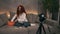 Curly red headed young girl beauty vlogger is talking in front of camera recording video for online blog in internet