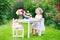 Curly sweet toddler girl playing tea party with a doll