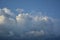 Curly thick clouds and clouds in the blue sky in the evening in late spring.