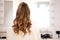 Curly woman sitting in the hairdressing salon