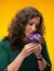 Curly woman smelling crocus flowers with close eyes