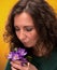Curly woman smelling crocus flowers with close eyes