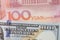 Currency exchange between China and America, closed up of 100 US Dollar banknote number on red 100 Chinese Yuan banknote