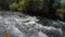 The current of the mountain river turns the boat with tourists between the rocks