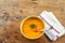 Curried carrot soup with cream and fresh herbs old natural wooden table