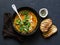 Curried red lentil tomato and coconut soup - delicious vegetarian food on dark background