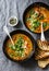 Curried red lentil tomato and coconut soup - delicious vegetarian food on grey background, top view.