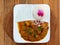 Curry and rice on wooden table with pink flower