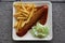 Currywurst curry sausage with french fries and cucumber salad and tomato ketchup