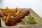 Currywurst curry sausage with french fries and cucumber salad and tomato ketchup