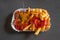 Currywurst with french fries on a paper plate