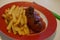 Currywurst and pommes on a plate. Cuisine, junk.