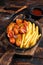 Currywurst Sausages with Curry spice on wursts served French fries in a pan. Dark wooden background. Top view