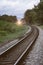 The curve of railway near train station with tree at left and right side of railway,vintage filtered image,