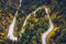 Curved bending road in the forest. Aerial image of a road. Forrest pattern. Scenic curvy road seen from a drone in autumn. Aerial