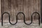 Curved bike rack in front of wooden wall