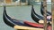 Curved bows of black gondola boats on Grand Canal, romantic atmosphere, Venice