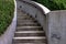 Curved concrete staircase with green hedges