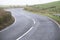 Curved country empty rural road white lines and hedge