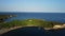 Curved green cliff in the Mediterranean sea and bay of water with standing boats for marine walks