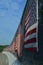 Curved Line of American flags on sunny side of highway overpass fence