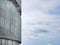 Curved Metal Building Facade Against Blue Cloudy Sky