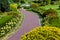 A curved path of paving slabs in a park area with landscape design.